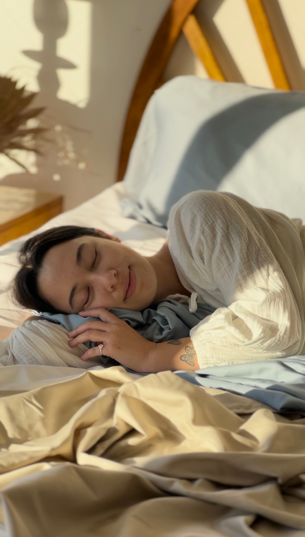 Woman sleeping on cooling eucalyptus sheets in beige with soft, breathable fabric and natural light