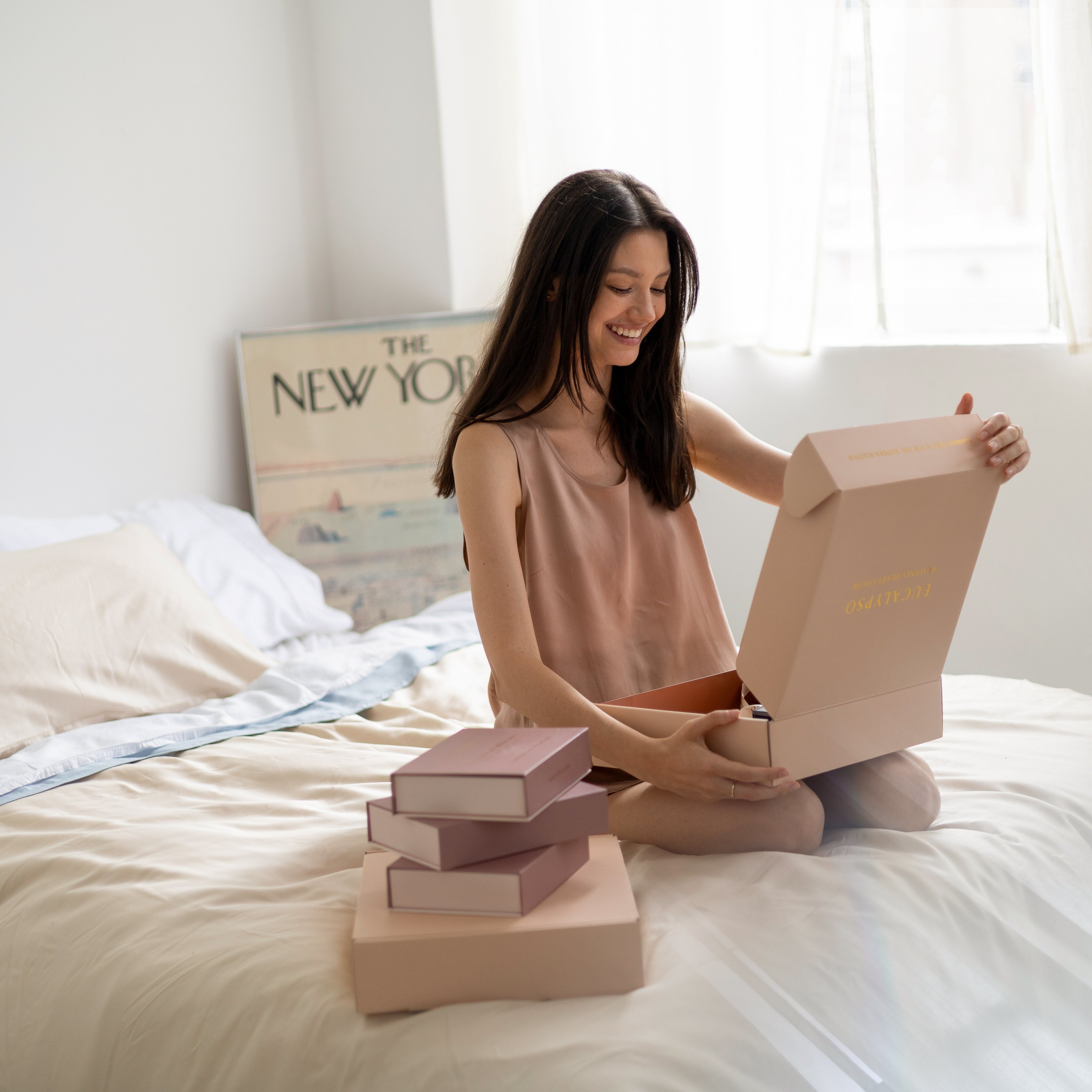 Customer unboxing Eucalypso eucalyptus bedding on bed, highlighting premium packaging and sleep essentials