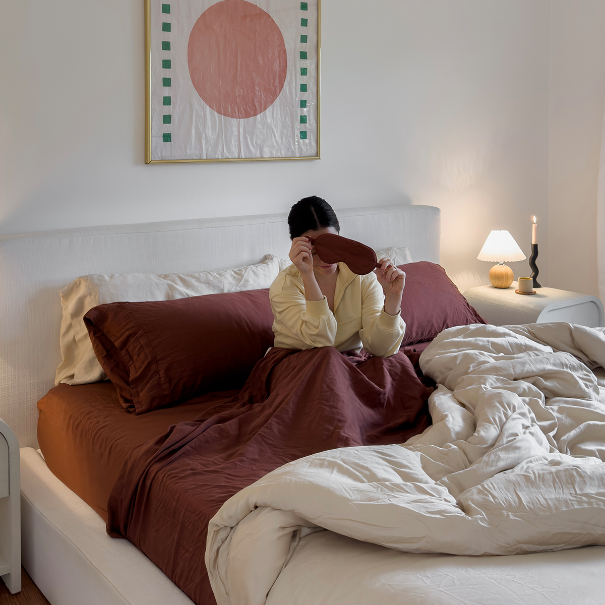 Person relaxing in bed with Eucalypso eucalyptus sheets and sleep mask, styled for soft, breathable, and temperature-regulating sleep