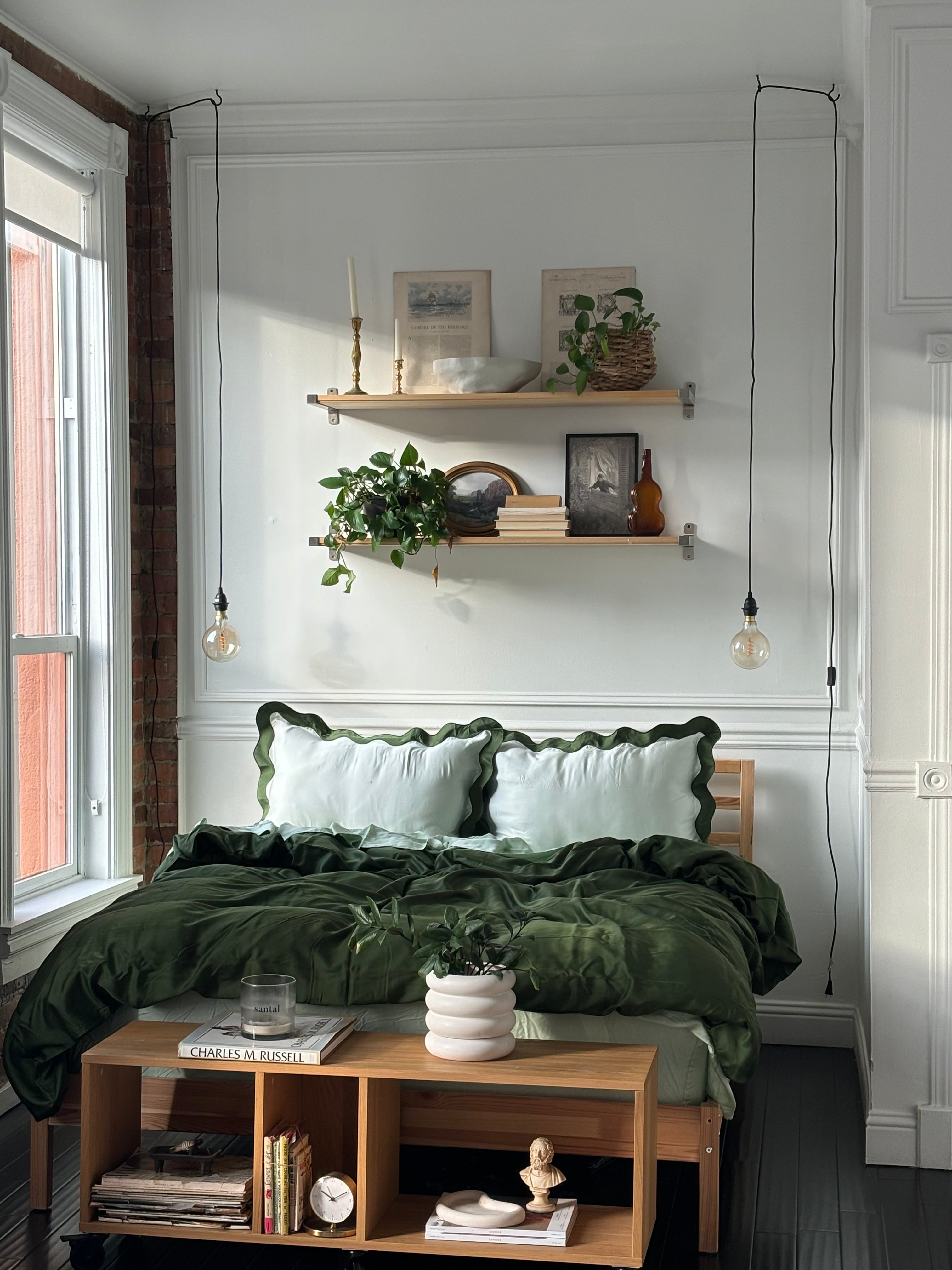 eucalyptus tencel sheets in forest green and light green styled in bed with scalloped green eucalyptus pillowcases