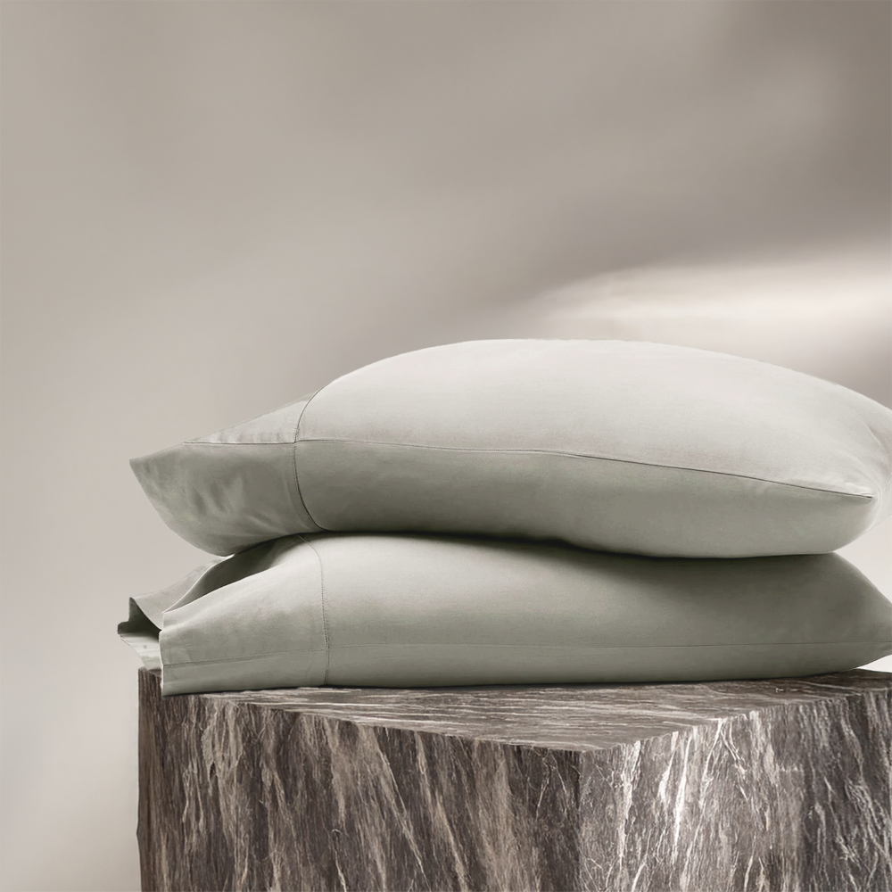 Eucalyptus white pillowcases stacked, showing smooth fabric and subtle sheen.