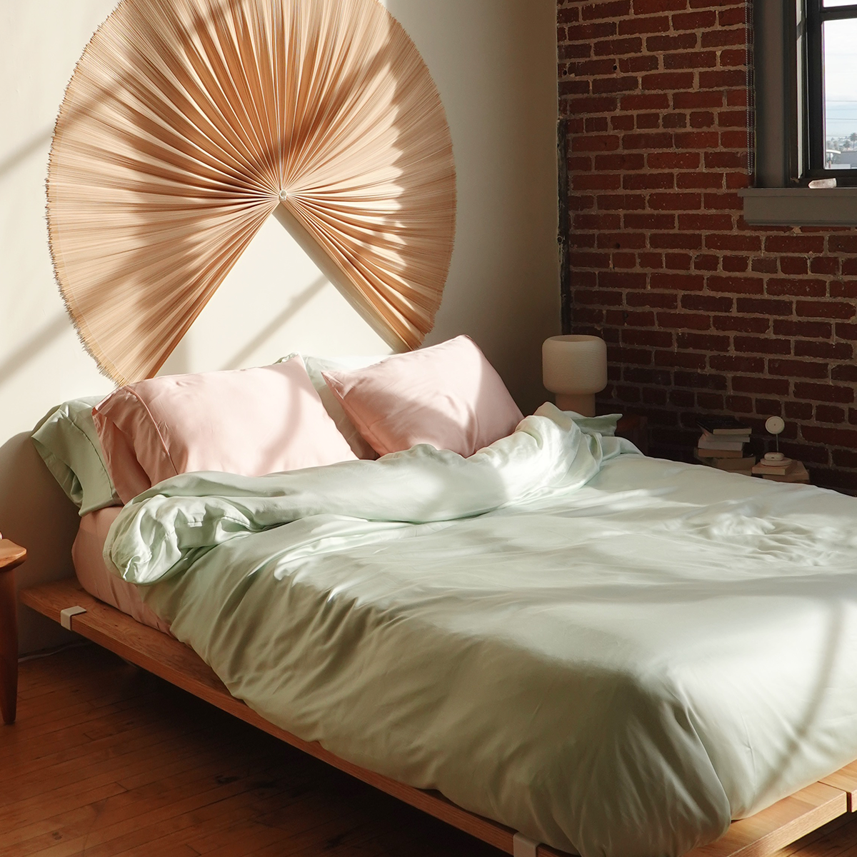 Silky soft eucalyptus tencel sheets in pink and green, styled in soft lighting room