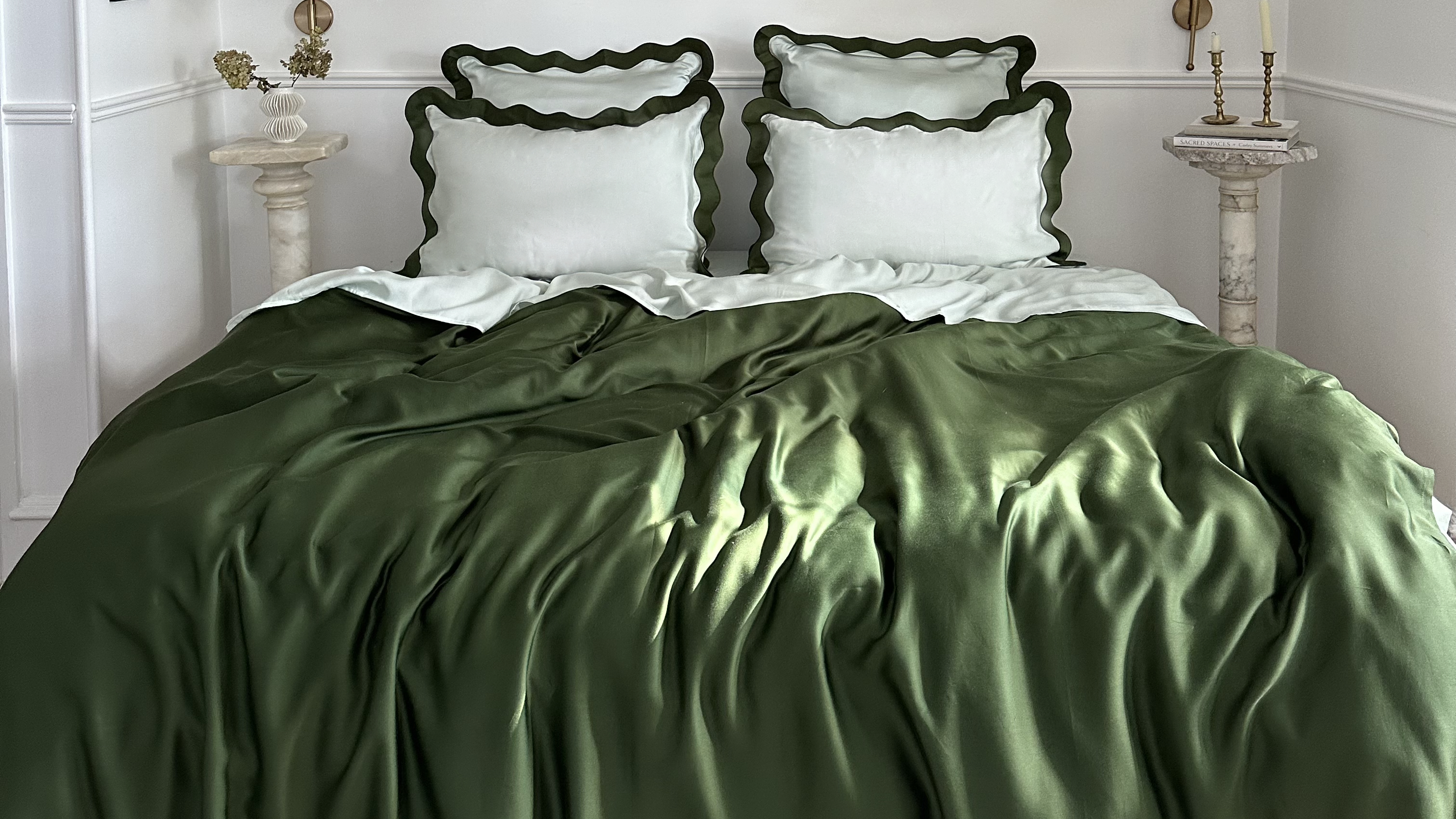 Cooling eucalyptus sheets and scalloped pillowcases styled on a bed.