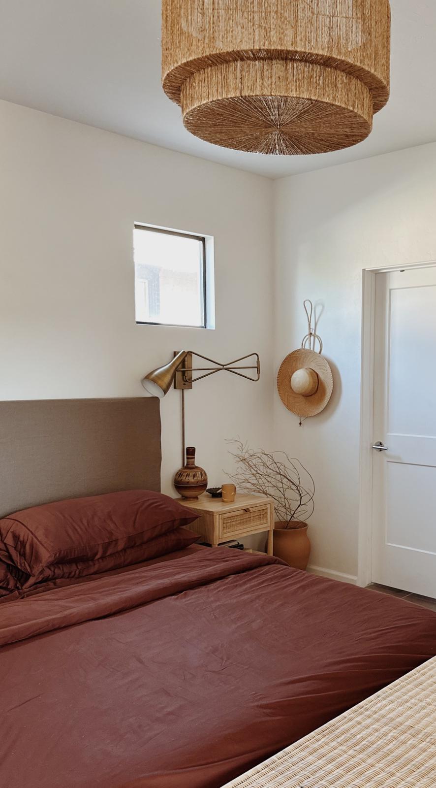A southwest styled bedroom with beautiful soft terracotta sheets styled in bed