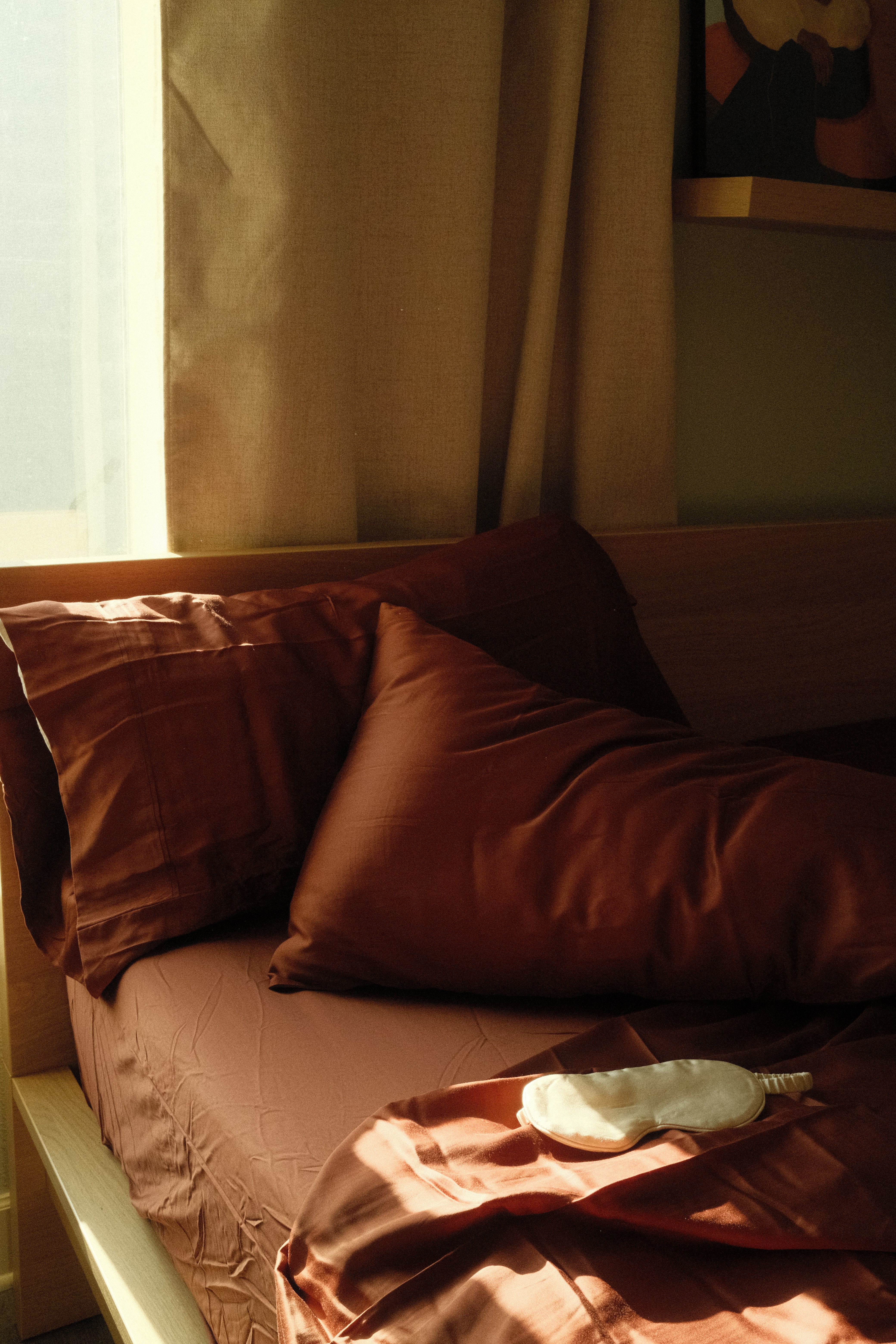 Close up of silky soft cooling eucalyptus sheets in a moody dark terracotta brown color